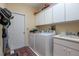 Bright laundry room with white cabinets, modern washer and dryer, and convenient sink area at 1628 Bent Oaks Blvd, Deland, FL 32724