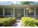 Inviting front porch featuring decorative plants, a charming flag, and a welcoming entrance at 1628 Bent Oaks Blvd, Deland, FL 32724