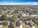 Sprawling aerial view of a neighborhood with tree coverage and blue skies at 1820 18Th St, Orange City, FL 32763