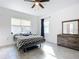 Bright bedroom featuring a ceiling fan, large window and wooden dresser with a mirror at 1820 18Th St, Orange City, FL 32763
