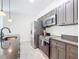 Modern kitchen with stainless steel appliances, gray cabinets, granite countertops, and tile floors at 1820 18Th St, Orange City, FL 32763