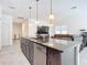 Stylish kitchen island with granite countertops, a sink, and seating, seamlessly connecting to the living area at 1820 18Th St, Orange City, FL 32763