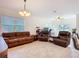 Spacious living room with tile floors, a ceiling fan, large windows and comfortable leather furniture at 1820 18Th St, Orange City, FL 32763
