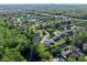 An aerial view shows homes situated near lush greenery, a river, and a roadway at 19 Twin River Dr, Ormond Beach, FL 32174