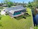 Aerial view of a screened-in pool with an immaculate lawn and peaceful canal in the backyard at 19 Twin River Dr, Ormond Beach, FL 32174