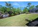 Lush green backyard overlooking a canal with a boat dock, complemented by a screened-in patio area at 19 Twin River Dr, Ormond Beach, FL 32174