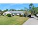 Charming single-story home with a well-manicured lawn, flowering bushes, and a long concrete driveway at 19 Twin River Dr, Ormond Beach, FL 32174