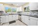 Well-lit kitchen featuring white cabinetry, stainless steel dishwasher, and a mosaic tile backsplash at 19 Twin River Dr, Ormond Beach, FL 32174