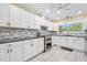 Bright, well-equipped kitchen with white cabinetry, granite counters, and stainless steel appliances at 19 Twin River Dr, Ormond Beach, FL 32174