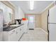 Bright laundry room with white cabinets, sink, modern washer and dryer, and a door to the outside at 19 Twin River Dr, Ormond Beach, FL 32174