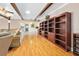 Spacious living room with hardwood floors, exposed beams, and a built-in wooden bookshelf at 19 Twin River Dr, Ormond Beach, FL 32174