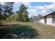 Lush backyard featuring scattered trees, green grass, and a view of the home's back exterior at 2017 Monterey Dr, Deltona, FL 32738