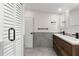 Modern bathroom with double sinks, wood cabinets, gray tile, and a closet with a louvered door at 205 Mary Ave, New Smyrna Beach, FL 32168