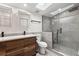 Modern bathroom featuring double sinks, wood cabinetry, gray tile, and a glass-enclosed shower with a skylight at 205 Mary Ave, New Smyrna Beach, FL 32168