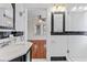 Bathroom with a vintage-style sink, tiled walls, and a view into a bedroom with hardwood floors at 205 Mary Ave, New Smyrna Beach, FL 32168