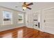 Bedroom with polished hardwood floors, ceiling fan, and view of adjacent bathroom at 205 Mary Ave, New Smyrna Beach, FL 32168