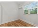 Bright bedroom featuring wood floors, a large window, and modern wall mounted air conditioner at 205 Mary Ave, New Smyrna Beach, FL 32168