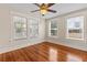 Sunlit bedroom with hardwood floors, ceiling fan, and three large windows at 205 Mary Ave, New Smyrna Beach, FL 32168