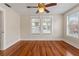 Bedroom with gleaming hardwood floors, ceiling fan, and lots of natural light from the windows at 205 Mary Ave, New Smyrna Beach, FL 32168