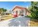 Charming pink house with a bright red front door, white trim, and a well-manicured lawn at 205 Mary Ave, New Smyrna Beach, FL 32168