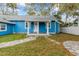 Charming blue home with a well-manicured front yard and covered porch at 205 Mary Ave, New Smyrna Beach, FL 32168