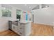 Bright, modern kitchen with white cabinets, stainless steel appliances, a farmhouse sink, and hardwood floors at 205 Mary Ave, New Smyrna Beach, FL 32168