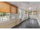 Bright sunroom with lots of windows, gray wood floors and overhead ceiling fans at 205 Mary Ave, New Smyrna Beach, FL 32168