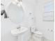 Bright bathroom featuring a pedestal sink, round mirror, and window with white blinds at 2090 Prairie Sage Ln, Longwood, FL 32750