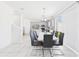 Bright dining area featuring a modern table with gray chairs, with kitchen and stainless appliances in the background at 2090 Prairie Sage Ln, Longwood, FL 32750