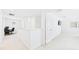 Bright hallway with white walls and carpet leading to an office space and bedroom at 2090 Prairie Sage Ln, Longwood, FL 32750