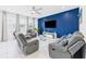 Cozy living room features a blue accent wall, tile floors, and comfortable gray reclining furniture at 2090 Prairie Sage Ln, Longwood, FL 32750