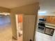 View into updated kitchen featuring granite countertops, stainless steel appliances, and nearby bathroom at 2200 S Palmetto Ave # C040, Daytona Beach, FL 32119