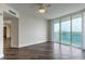 Bedroom with wood flooring, ceiling fan, and sliding doors to a balcony with city views at 231 Riverside Dr # 1003-1, Daytona Beach, FL 32117
