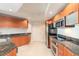 Modern kitchen with wood cabinets, granite countertops and stainless steel appliances at 231 Riverside Dr # 1003-1, Daytona Beach, FL 32117