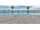 Expansive pool deck features waterfront views, sun loungers, and palm trees for shade at 231 Riverside Dr # 1003-1, Daytona Beach, FL 32117