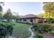Well-maintained backyard with lush landscaping, mature trees, and a neatly kept lawn surrounding the brick home at 232 Westchester Dr, Deland, FL 32724