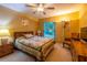 Cozy bedroom with a large window, ceiling fan, side table, and warm colors at 232 Westchester Dr, Deland, FL 32724