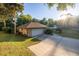 Side view of the home, driveway, garage and landscaping under a sunny sky at 232 Westchester Dr, Deland, FL 32724