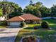 Aerial of this single-story home with a manicured lawn, shrubbery, and an attached garage at 232 Westchester Dr, Deland, FL 32724