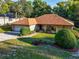 A single-story home featuring a green lawn, front porch, walkway, and mature shrubbery at 232 Westchester Dr, Deland, FL 32724