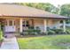 Welcoming front porch with seating and a well-maintained lawn and landscaping at 232 Westchester Dr, Deland, FL 32724