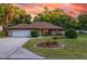 Charming brick home featuring a landscaped front yard, a driveway, and a two-car garage at 232 Westchester Dr, Deland, FL 32724