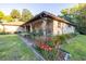 Charming brick home featuring a lush front yard with vibrant flower beds and a welcoming covered porch at 232 Westchester Dr, Deland, FL 32724