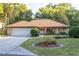 Charming brick home featuring a landscaped front yard, a driveway, and a two-car garage at 232 Westchester Dr, Deland, FL 32724
