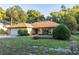 Charming single-story home with a manicured front yard, lush landscaping, and a two-car garage at 232 Westchester Dr, Deland, FL 32724