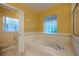 Bathroom featuring a large soaking tub with glass block window for privacy and natural light at 232 Westchester Dr, Deland, FL 32724