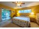 Bright bedroom featuring a ceiling fan, large window, and sliding glass door to a screened porch at 232 Westchester Dr, Deland, FL 32724