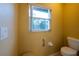 Bright powder room with toilet and window at 232 Westchester Dr, Deland, FL 32724