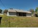 A view of the home and screened-in back patio in the backyard with healthy grass at 2383 Dumas Dr, Deltona, FL 32738