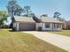 Single-story home with a spacious driveway, attached garage, and well-kept lawn at 2383 Dumas Dr, Deltona, FL 32738